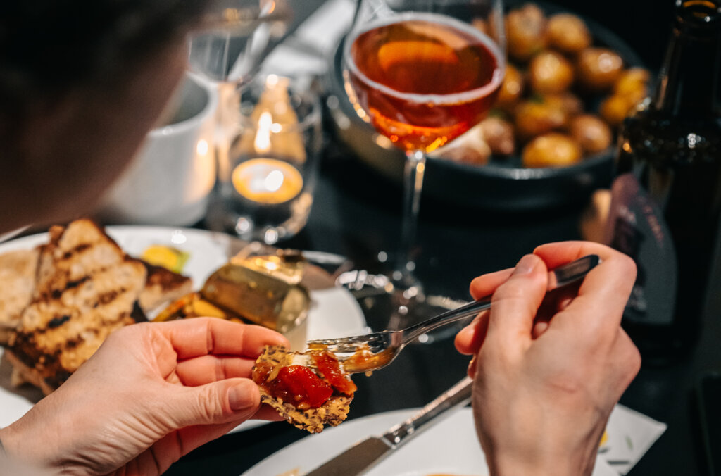 Person eating cheese with jam and crackers in Bistro Nobel.
