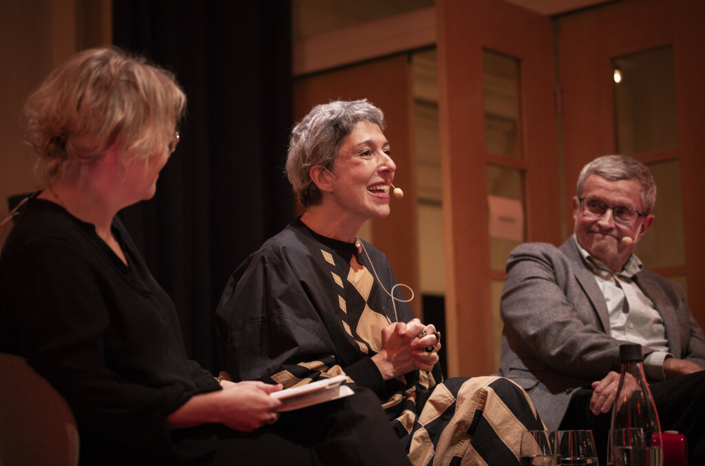 Tre personer på en scen som samtalar.