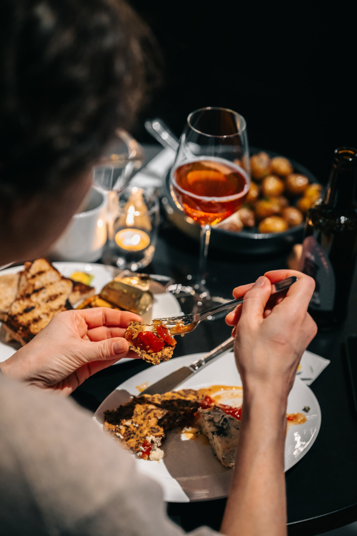Person äter ost med kex och marmelad i Bistro Nobel.