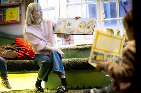 Photo of a woman reading a book for children