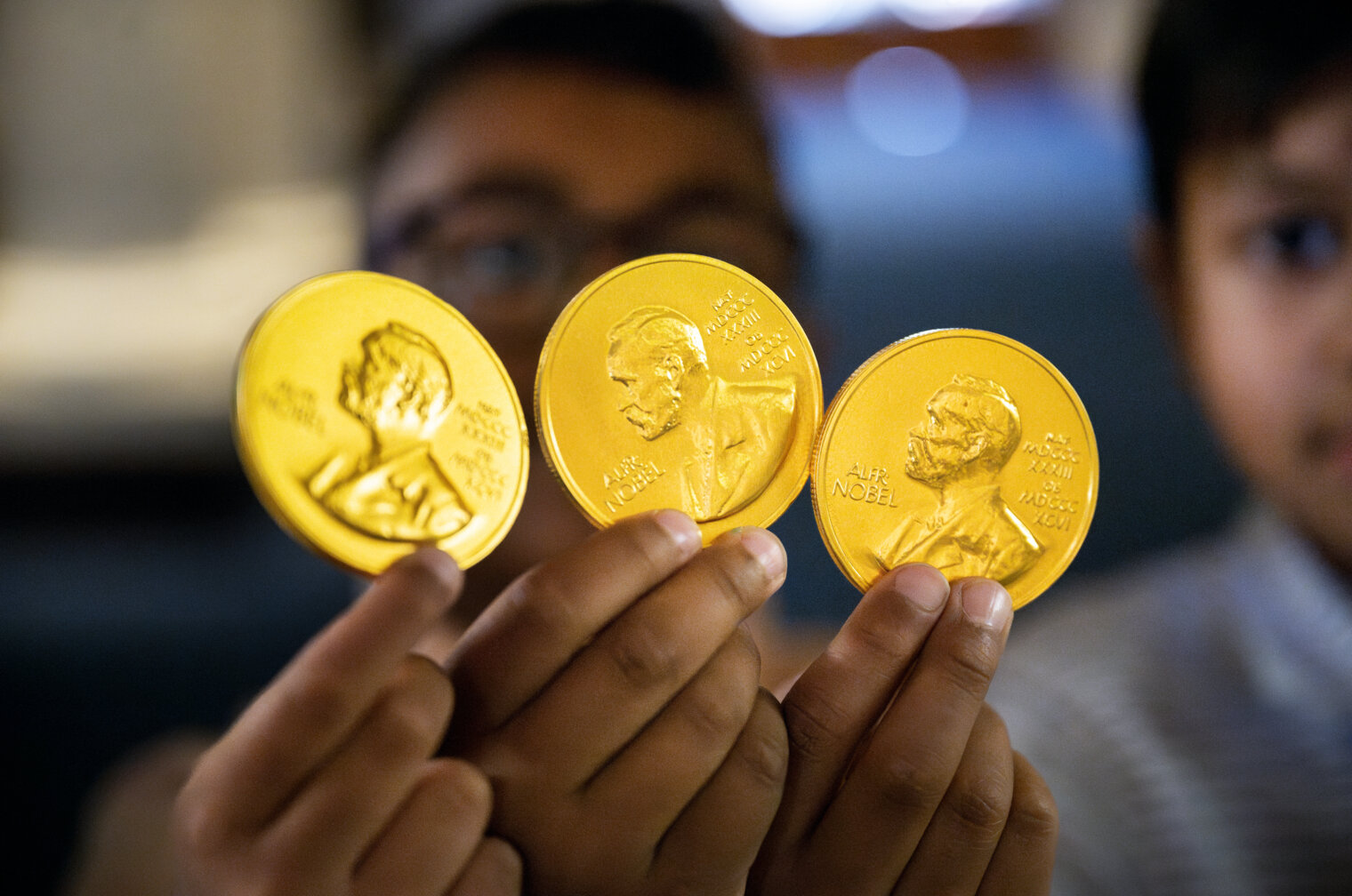 Barn håller chokladmedaljer.