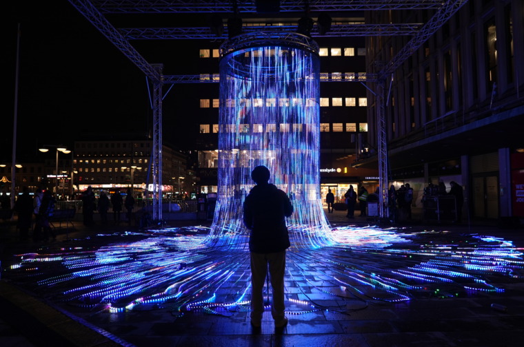 A silhouette in front of the light artwork Flux at the Nobel Week Lights 2024 light art festival